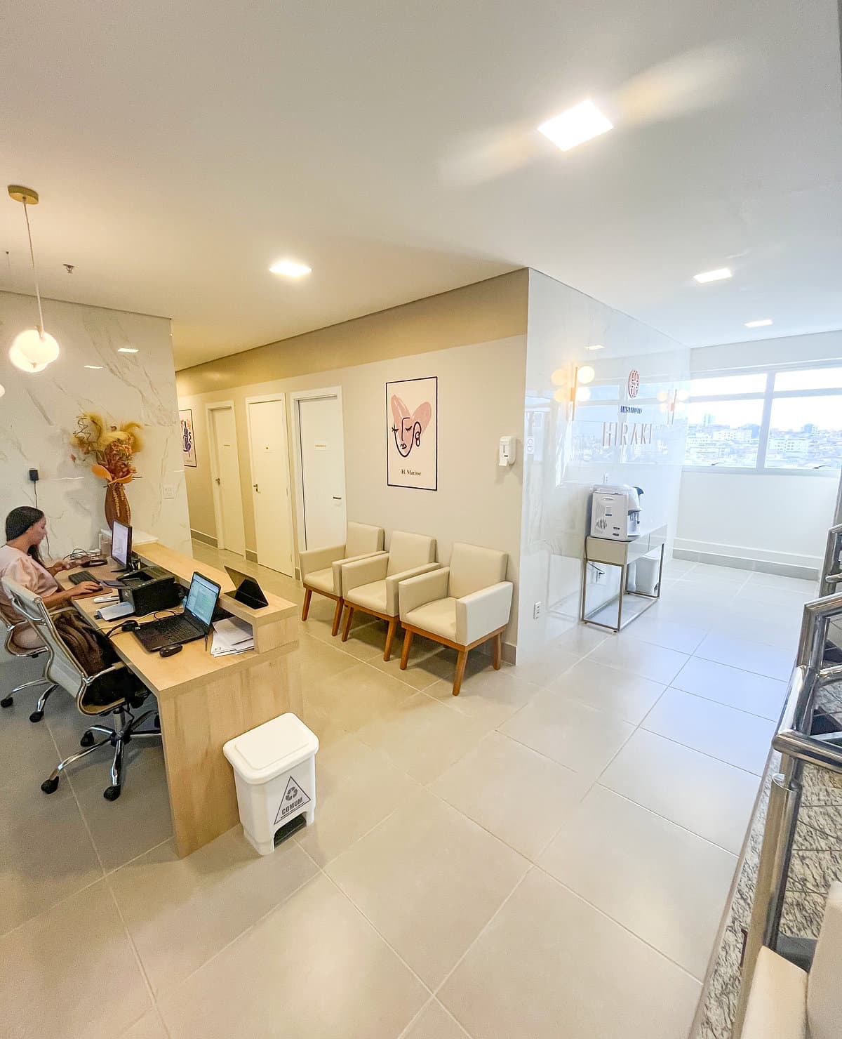 Sala de espera da unidade Lourdes do Instituto Hiraki com balcão de atendimento e poltronas